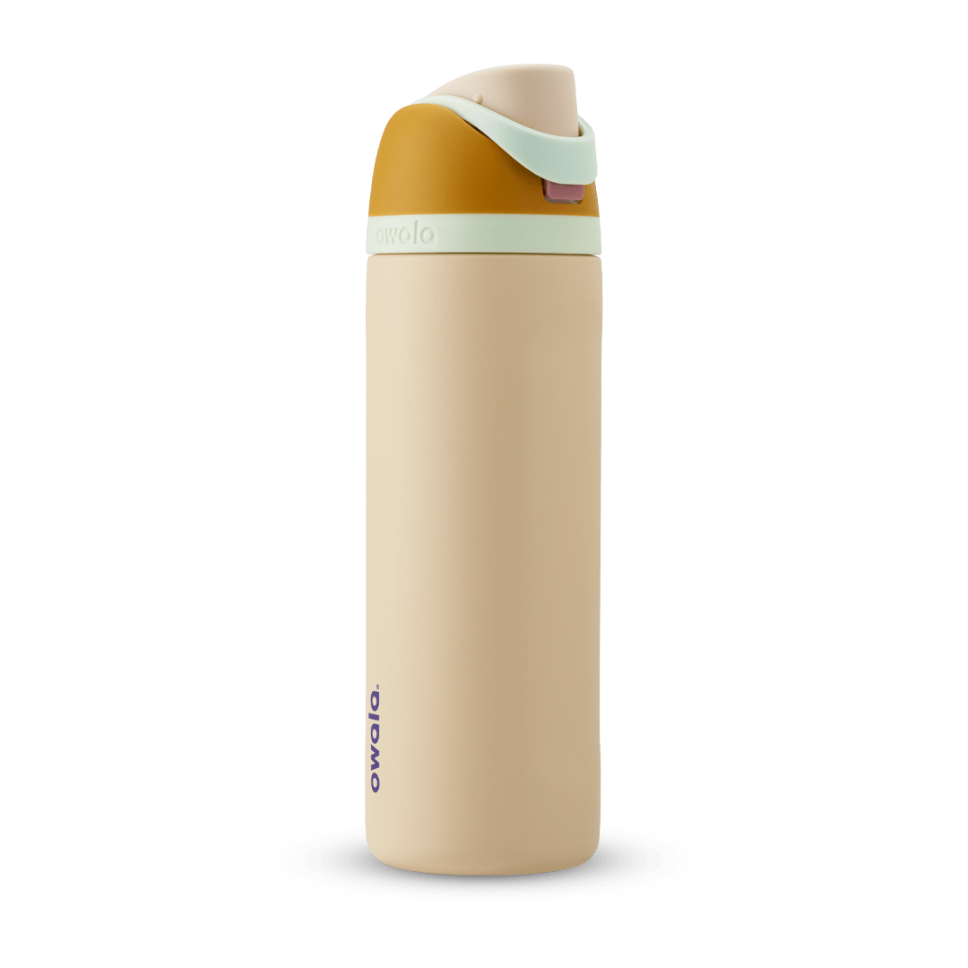 FreeSip 24oz water bottle, sandy cream body with warm golden-yellow lid base, mint green flip cap, and carry loop