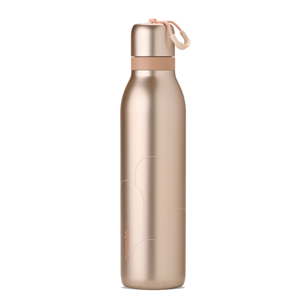 Owala Birthday Bash Paparazzi 24oz FreeSip Twist bottle in metallic champagne gold body and matching twist cap, with a peach twist cap accent band and cream carry string with grip