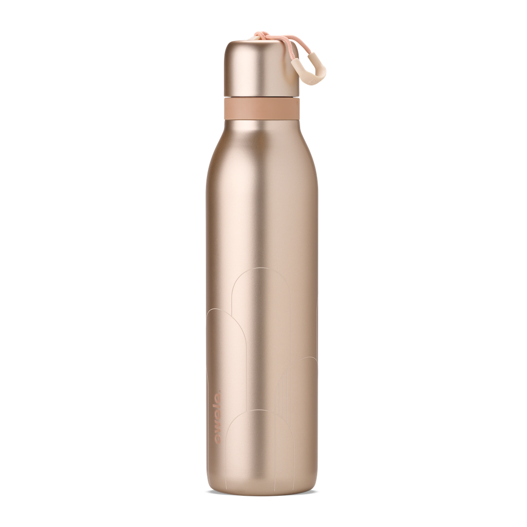 Owala Birthday Bash Paparazzi 24oz FreeSip Twist bottle in metallic champagne gold body and matching twist cap, with a peach twist cap accent band and cream carry string with grip