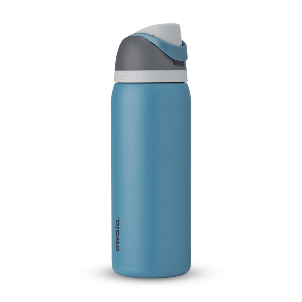 FreeSip 32oz in Blue Oasis, denim blue body with matching blue carry loop, dark gray flip cap, and white accent band