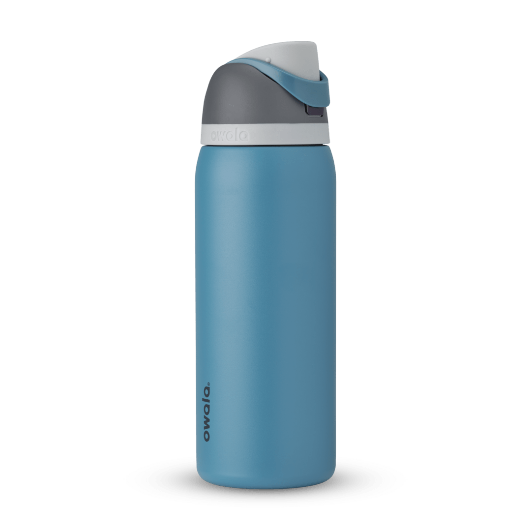 FreeSip 32oz in Blue Oasis, denim blue body with matching blue carry loop, dark gray flip cap, and white accent band