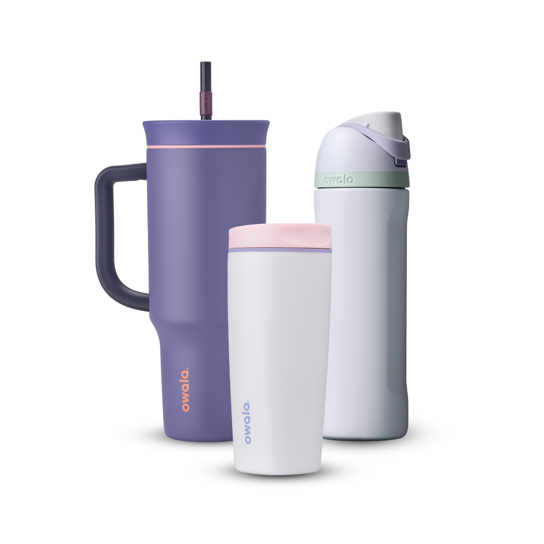 Owala All Day Bundle showing three bottles — a deep purple 40oz Tumbler with side handle, peach pink accent ring, and dark purple straw, a small white insulated cup with pink accent ring, and a white FreeSip with mint green accent band, lavender flip cap, and matching lavender carry loop