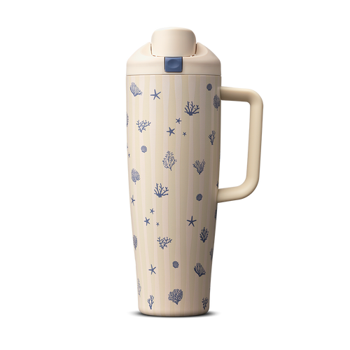 Owala Birthday Bash Coral Cabana 30oz FreeSip Tumbler; cream body with subtle vertical stripes scattered with small navy blue seashells, starfish, coral, and sea urchin illustrations, matching cream flip cap, lid, and side handle