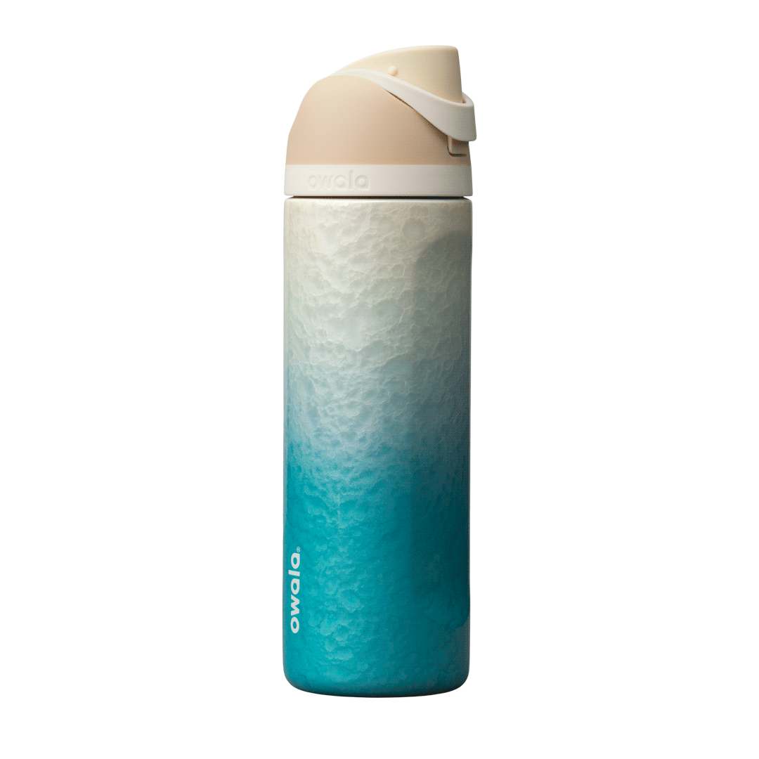 Owala Birthday Bash 24oz FreeSip Rolling In; gradient ombre from sandy cream at the top to vibrant teal blue at the base, with a cream-colored flip cap