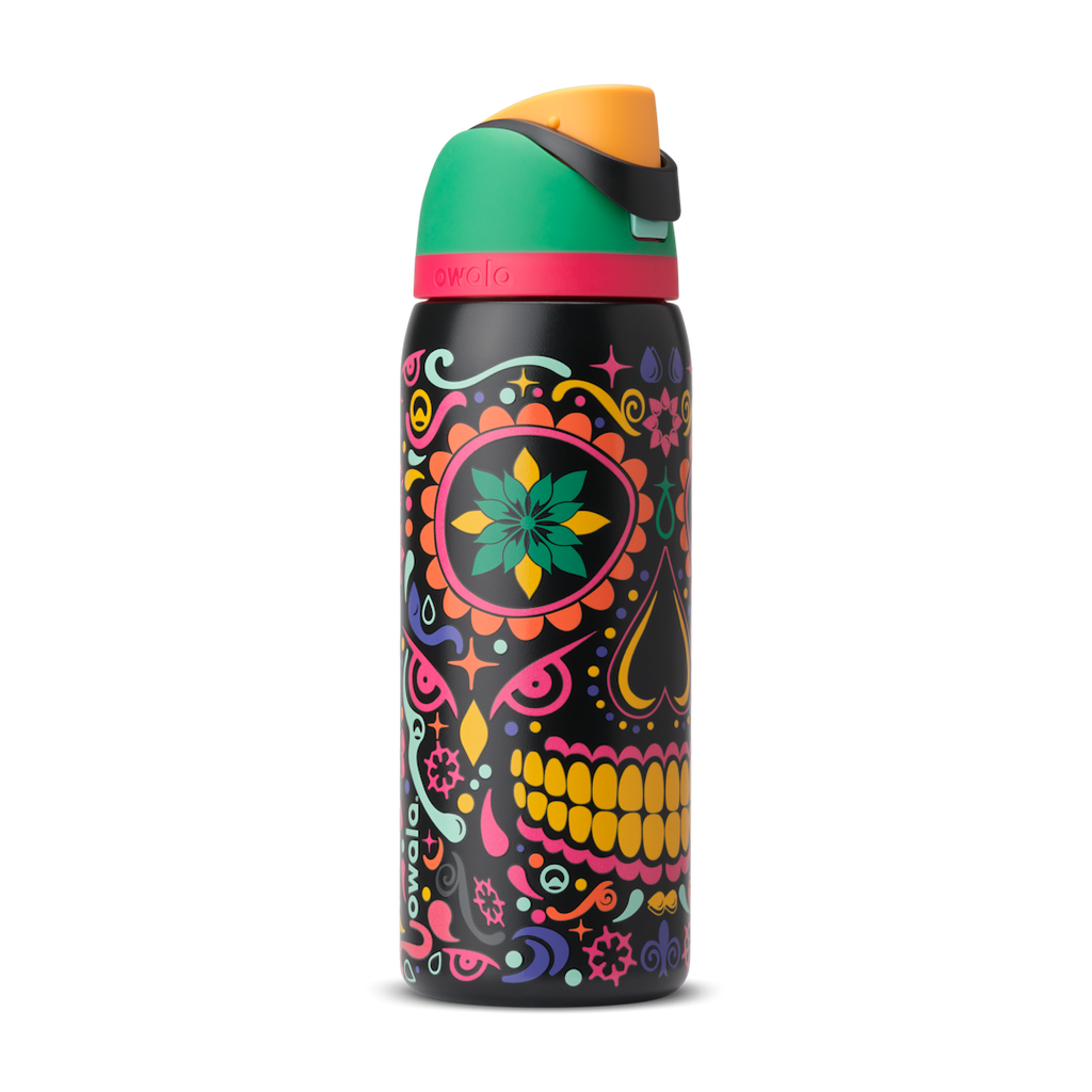 FreeSip 32oz in Sugar Skull, black body with colorful Day of the Dead sugar skull graphic in pink, yellow, green, and turquoise; green flip cap with orange detail, hot pink accent band on the lid; glows in the dark