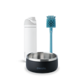 Owala FreeSip and Pet Bowl Bundle showing a white FreeSip bottle, a teal-handled bottle brush with blue bristles, and a dark charcoal stainless steel pet bowl with white Owala logo