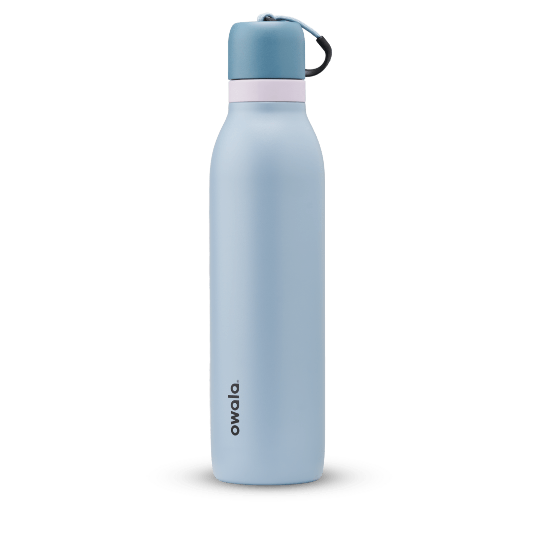 FreeSip Twist 24oz in Rainstorm, light powder blue insulated water bottle with darker slate blue twist cap, pale pink twist cap accent band, and dark navy carry string