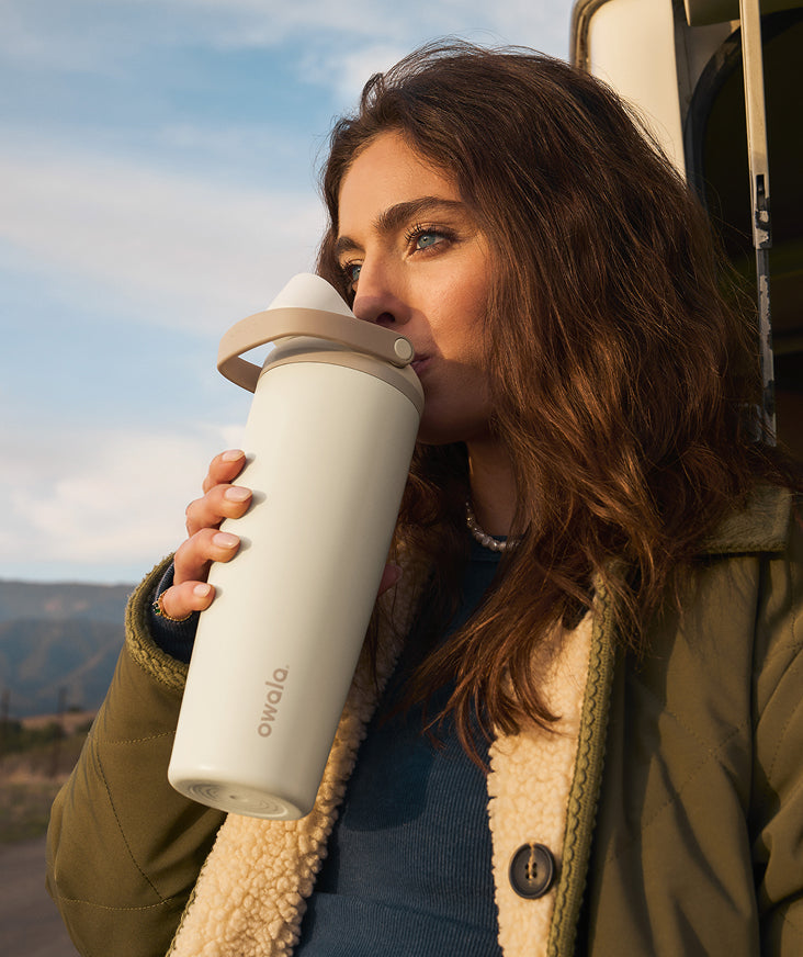 A woman holding an Owala SmoothSip coffee mug. Shop SmoothSip